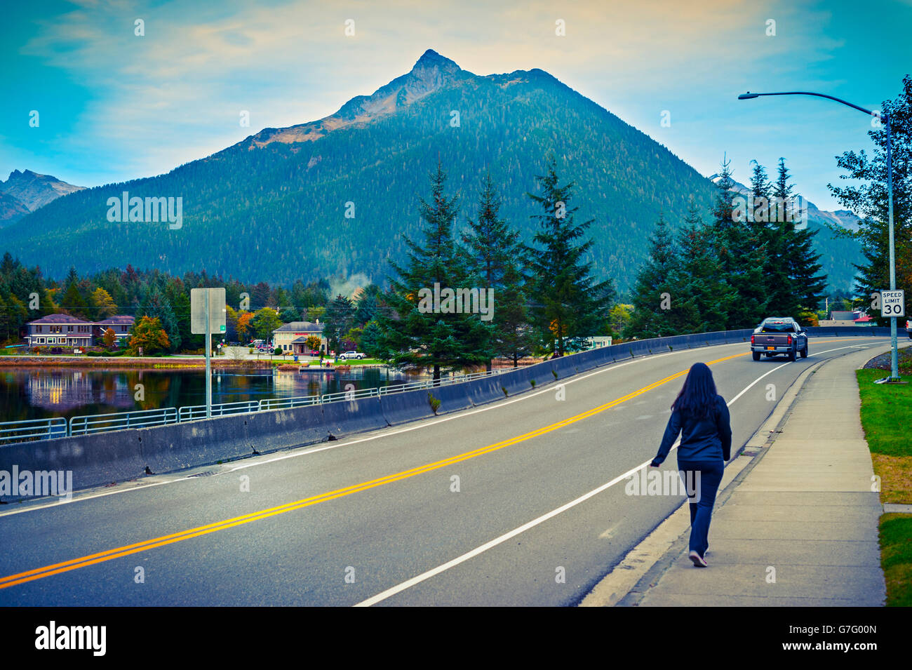 Passeggiate pedonali giù Halibut Point Road con Mount Verstovia nella distanza vicino al centro cittadino di Sitka, Alaska, Stati Uniti d'America. Foto Stock