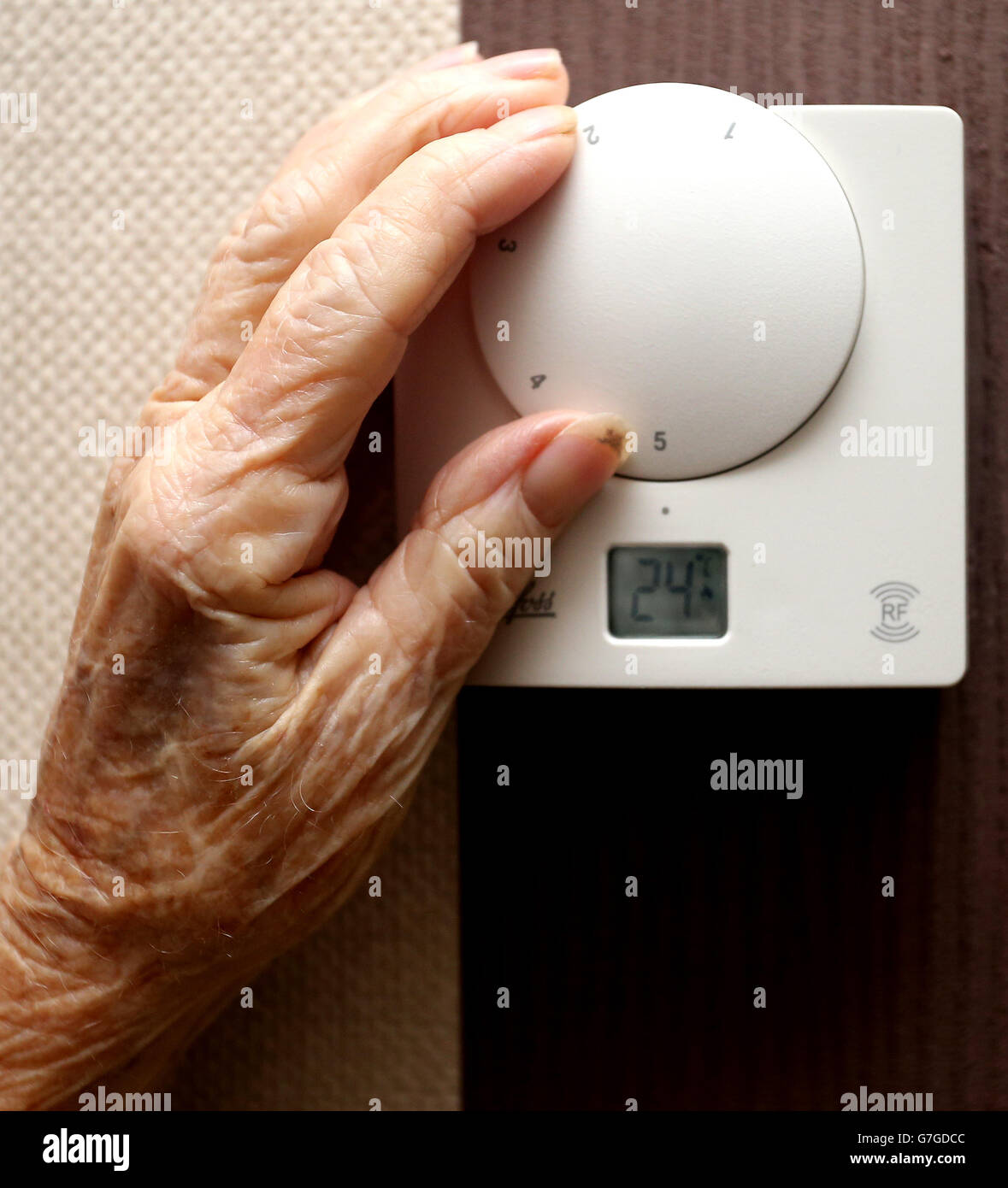 Una foto generica di una signora anziana che regola il suo termostato a casa a Liverpool. Foto Stock