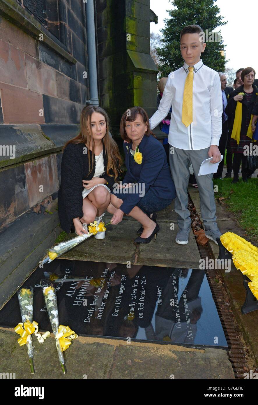 Barbara Henning (centro) e i suoi figli Lucy e Adam svelano una lapide commemorativa per l'operaio britannico assassinato Alan Henning alla chiesa parrocchiale di Eccles a Manchester. Foto Stock