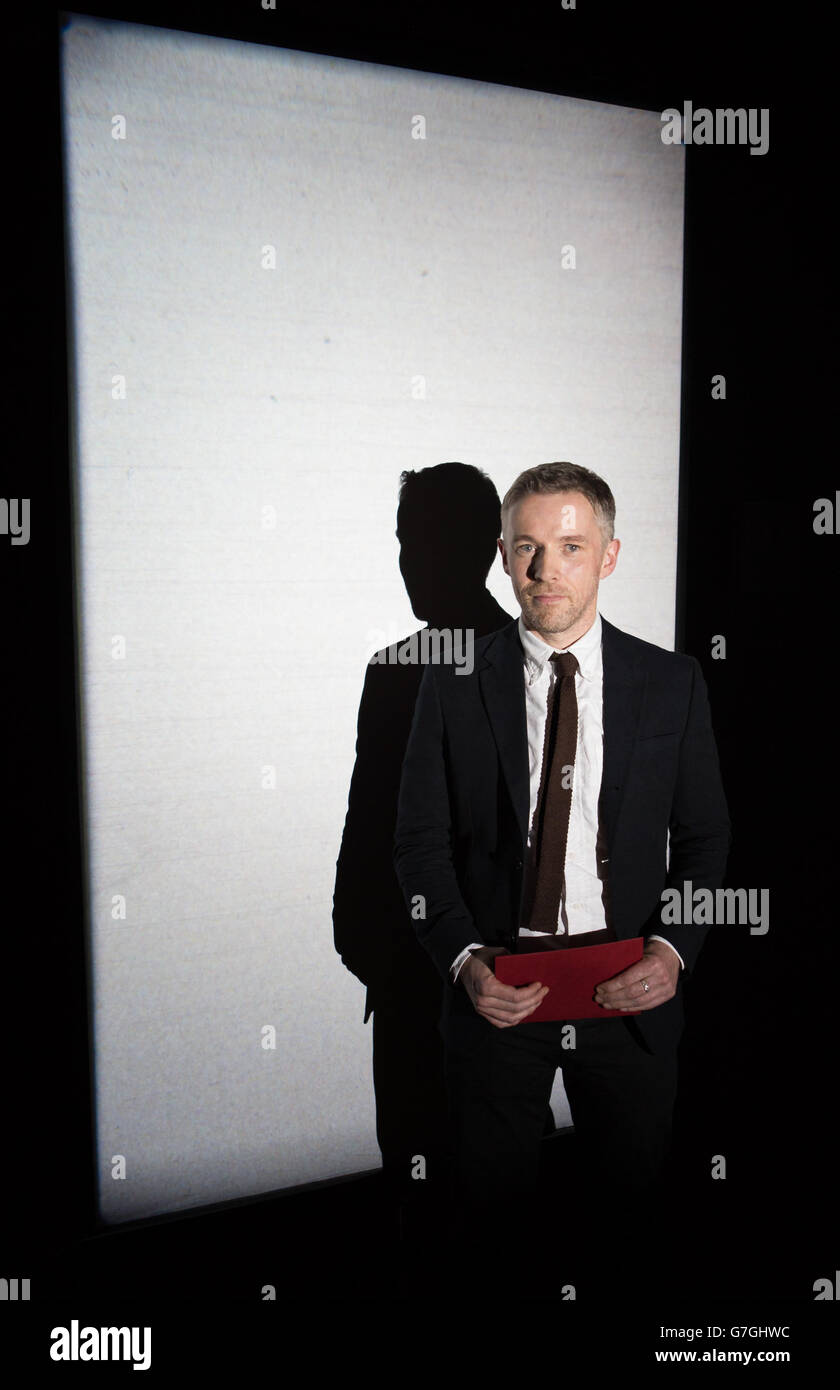 L'artista irlandese Duncan Campbell di fronte al suo film Stills da Sigmar 2008, come ha vinto il Turner Prize di quest'anno per la sua serie di film chiamato IT for Others, a Tate Britain nel centro di Londra. Foto Stock