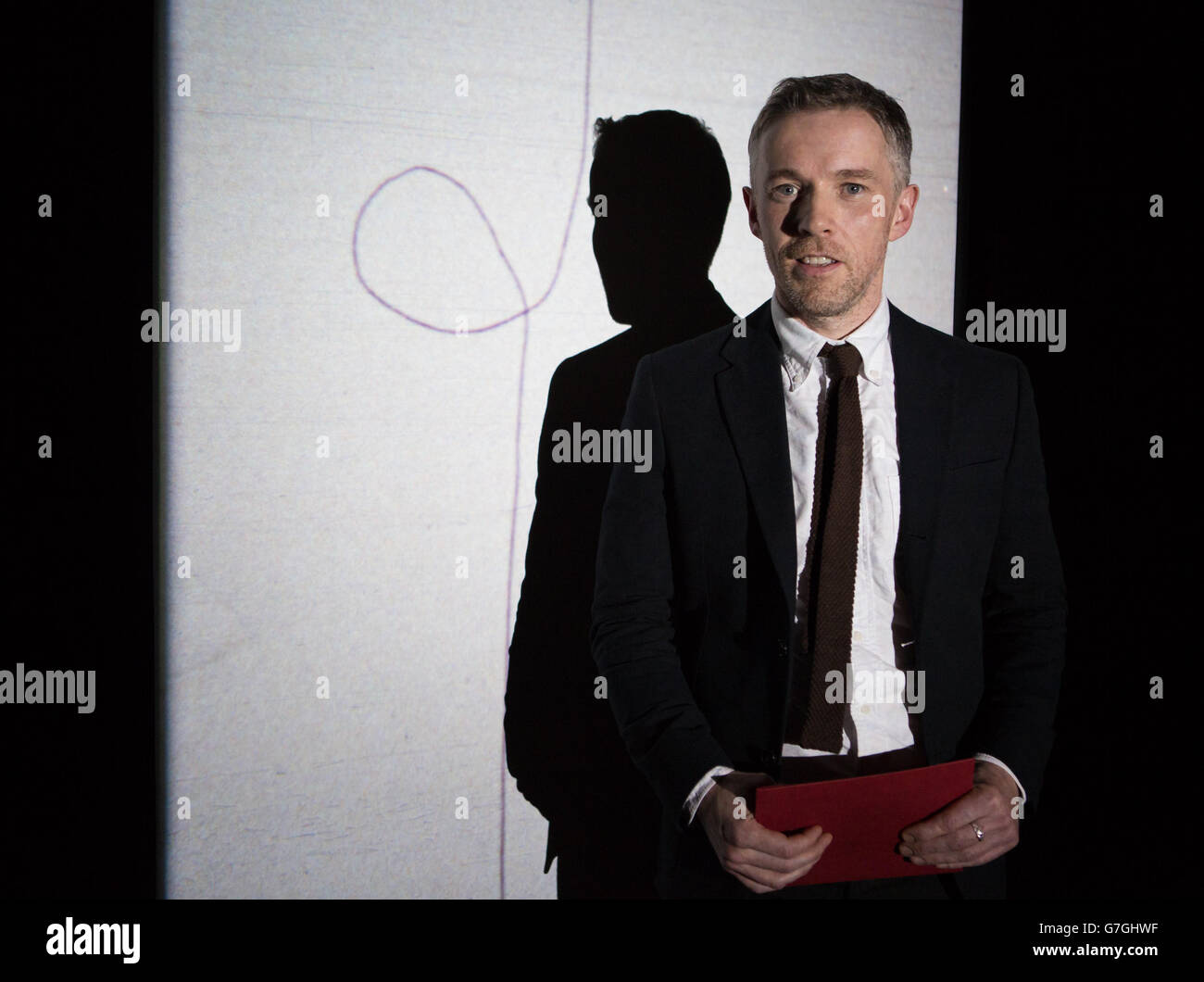 L'artista irlandese Duncan Campbell di fronte al suo film Stills da Sigmar 2008, come ha vinto il Turner Prize di quest'anno per la sua serie di film chiamato IT for Others, a Tate Britain nel centro di Londra. Foto Stock