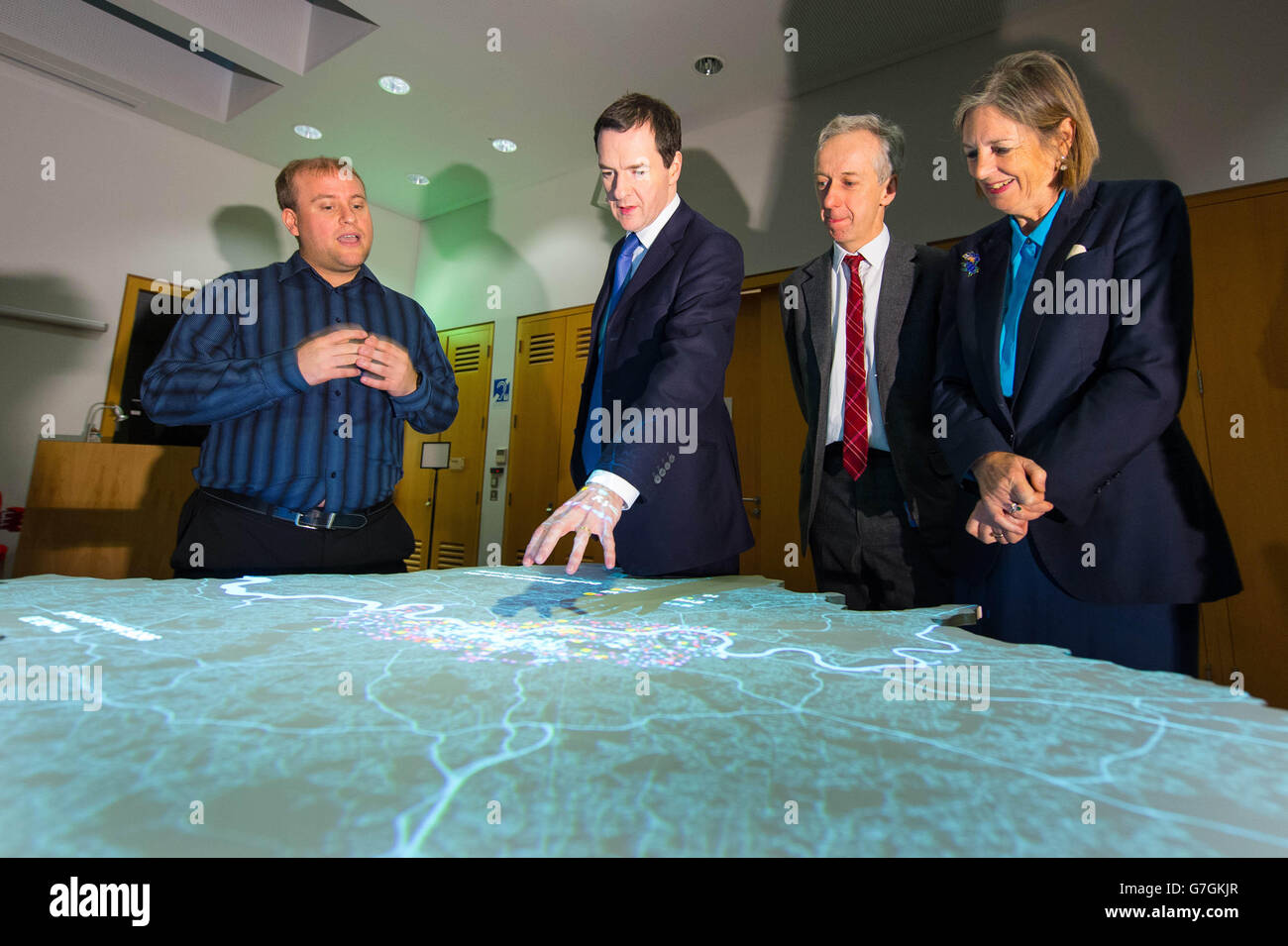 Docente in Big Data Analytics Steven Grey (a sinistra), dimostra la London Data Table che visualizza i dati analitici sulla capitale al Cancelliere dello scacchiere George Osborne, amministratore delegato della British Library Roly Keating e presidente della British Library Baroness Tessa Blackstone, Durante una visita per lanciare il Knowledge Quarter, presso la British Library, nel centro di Londra. Foto Stock