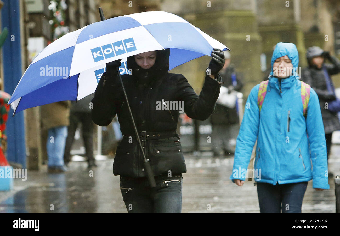 Una donna con un ombrello sul Royal Mile di Edimburgo, mentre la Gran Bretagna è stata colpita da una 'bomba meteorologica'. Foto Stock
