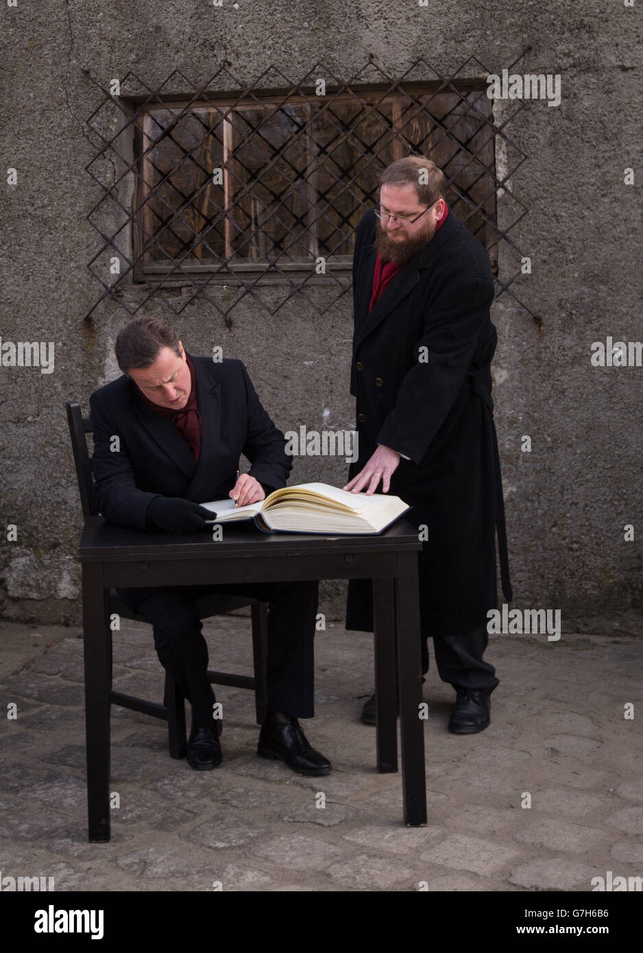 Il primo ministro David Cameron firma il libro degli ospiti fuori da una camera a gas nel campo di concentramento di Auschwitz in Polonia, come parte di una visita personale che ha fatto nei campi di concentramento di Auschwitz e Birkenau per la prima volta da quando è diventato primo ministro. Foto Stock