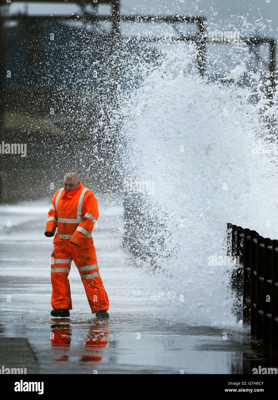 Un uomo sul lungomare di Saltcoats, Scozia, dato che le tempeste causano interruzioni in diverse parti del Regno Unito con interruzioni di corrente, cancellazioni di traghetti e treni e condizioni di guida difficili. Foto Stock