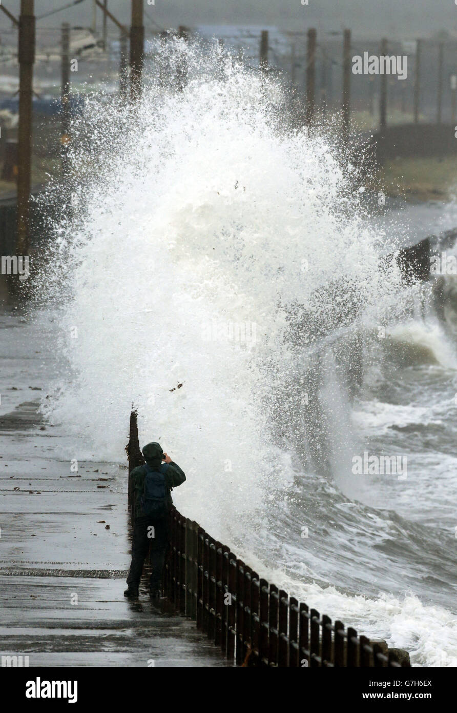 Un uomo sul lungomare di Saltcoats , Scozia, dato che le tempeste causano interruzioni in diverse parti del Regno Unito con interruzioni di corrente, cancellazioni di traghetti e treni e condizioni di guida difficili. Foto Stock