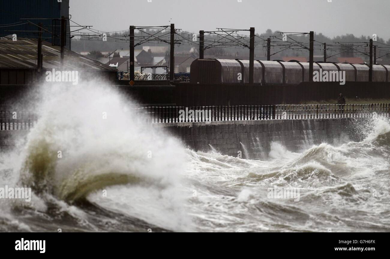 Un treno sul lungomare di Saltcoats, in Scozia, dato che le tempeste causano interruzioni in diverse parti del Regno Unito con interruzioni di corrente, cancellazioni di traghetti e treni e condizioni di guida difficili. Foto Stock