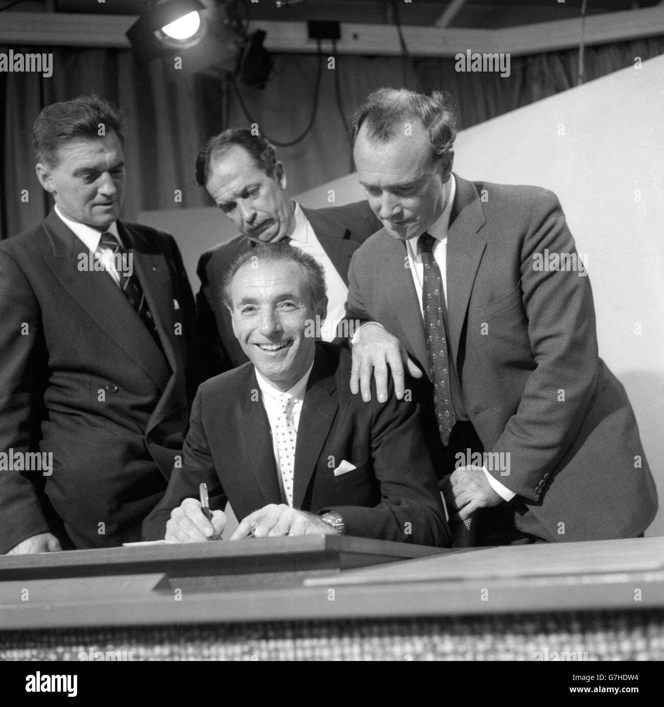 Stanley Matthews, Blackpool e Inghilterra di 46 anni, ha mostrato di firmare per Stoke City prima delle telecamere della BBC 'portsview' a Manchester. Guardando lui sono (l-r) Eric Hayward, assistente manager di Blackpool, Albert Hensall, presidente di Stoke City, e Tony Waddington, Direttore di Stoke City. Stoke era il primo club della lega di Matthews, quando giocò per loro nel 1932 all'età di 17 anni. Foto Stock