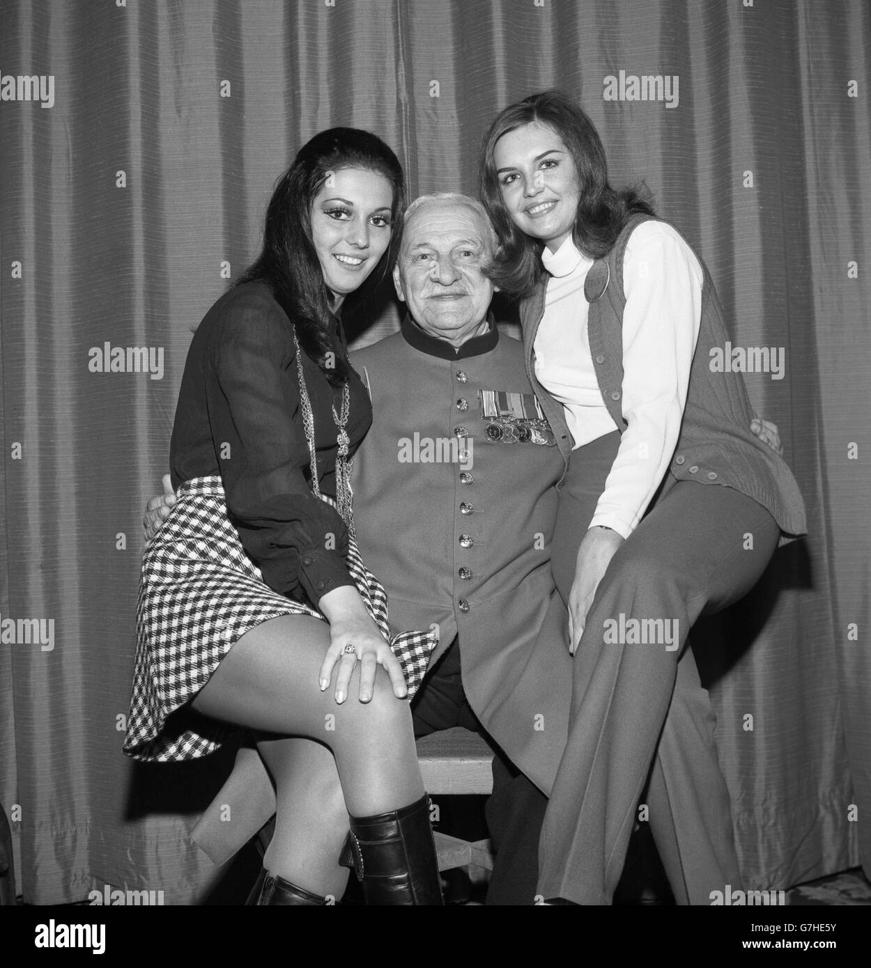 Chelsea Pensioner Company Sergeant Major James Nixon, 82 anni, incontra due concorrenti Miss World al Waldorf Hotel di Londra. Miss Venezuela marcia Rita Piazza, 18 (a sinistra), e Miss France Suzanne Angly, 17, sono stati tra i finalisti che hanno agito come hostess per un pranzo per pensionati dal Royal Hospital, Chelsea. Foto Stock