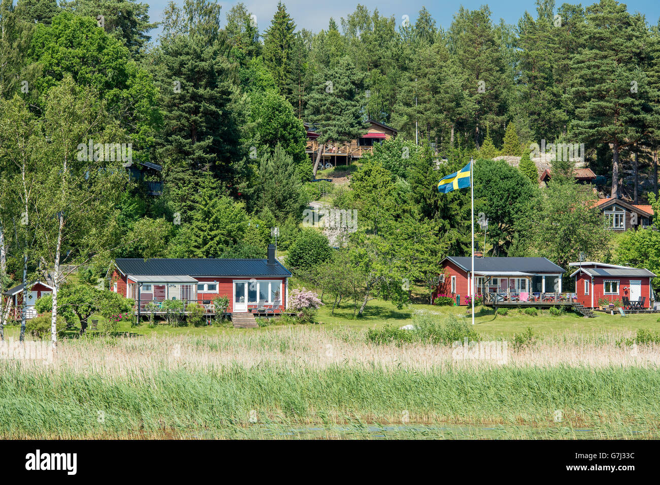 Tradizionale cottage estivi e case sulla costa orientale della Svezia durante la festa di mezza estate Foto Stock