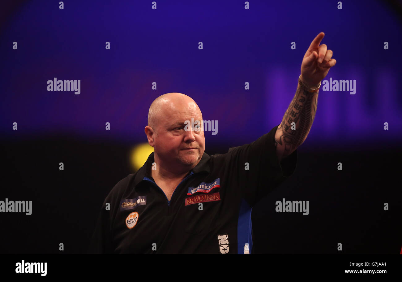 Andy Hamilton festeggia un 180 durante la sua partita contro Dave Richardson il campionato mondiale di freccette William Hill ad Alexandra Palace, Londra. Foto Stock