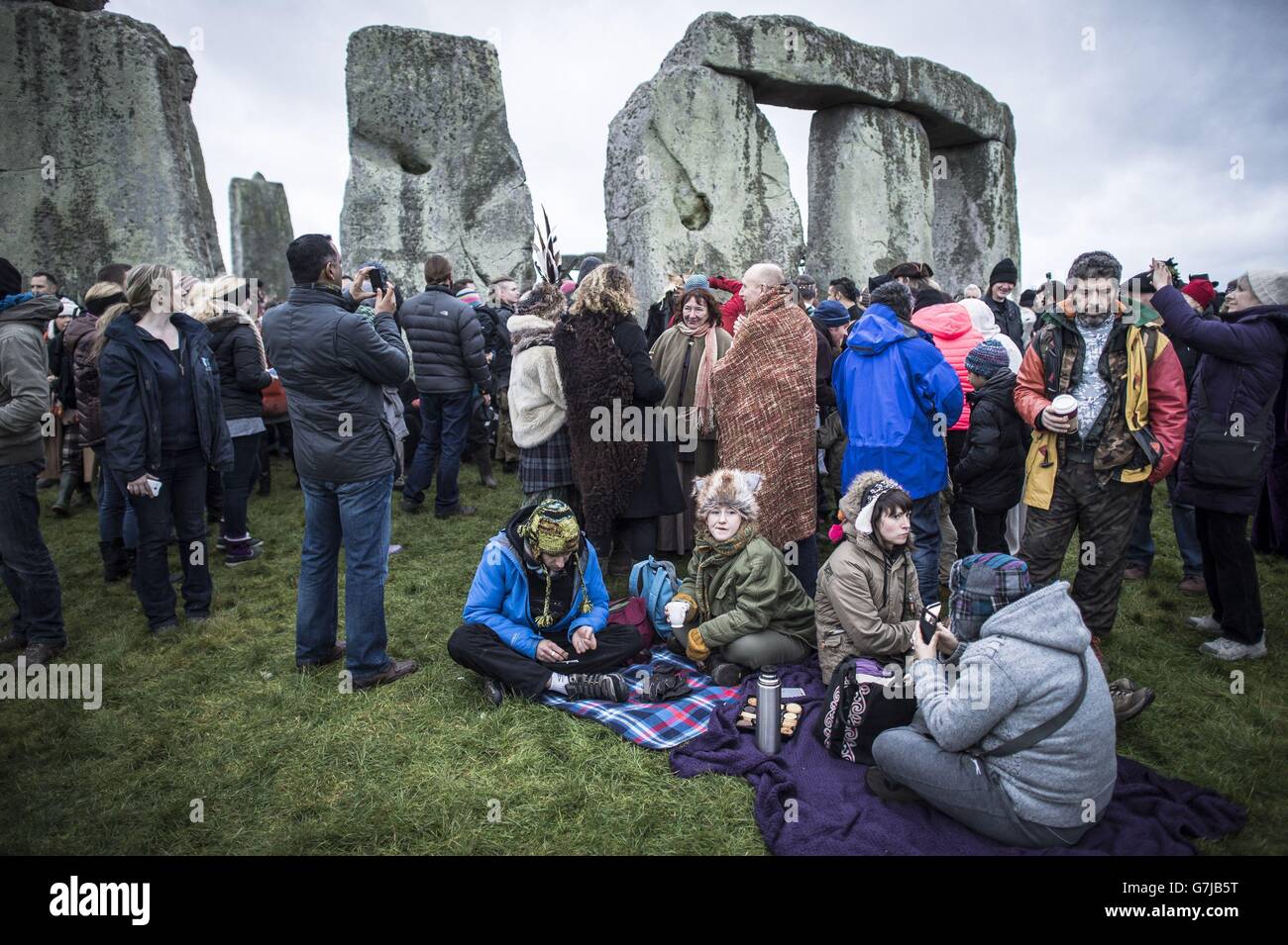 Le persone si rilassano a Stonehenge, nel Witshire, dove si riuniscono per celebrare il solstizio invernale. Foto Stock