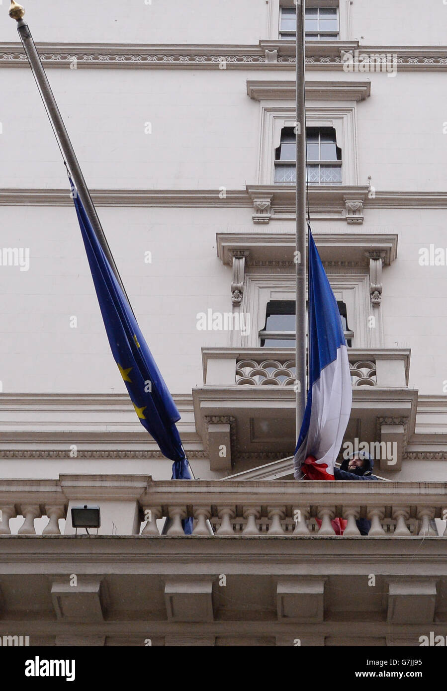 La bandiera francese è volata a metà albero fuori dall'ambasciata francese a Londra a coloro che sono stati uccisi nell'attentato terroristico di ieri a Parigi sulla rivista satirica francese Charlie Hebdo. Foto Stock