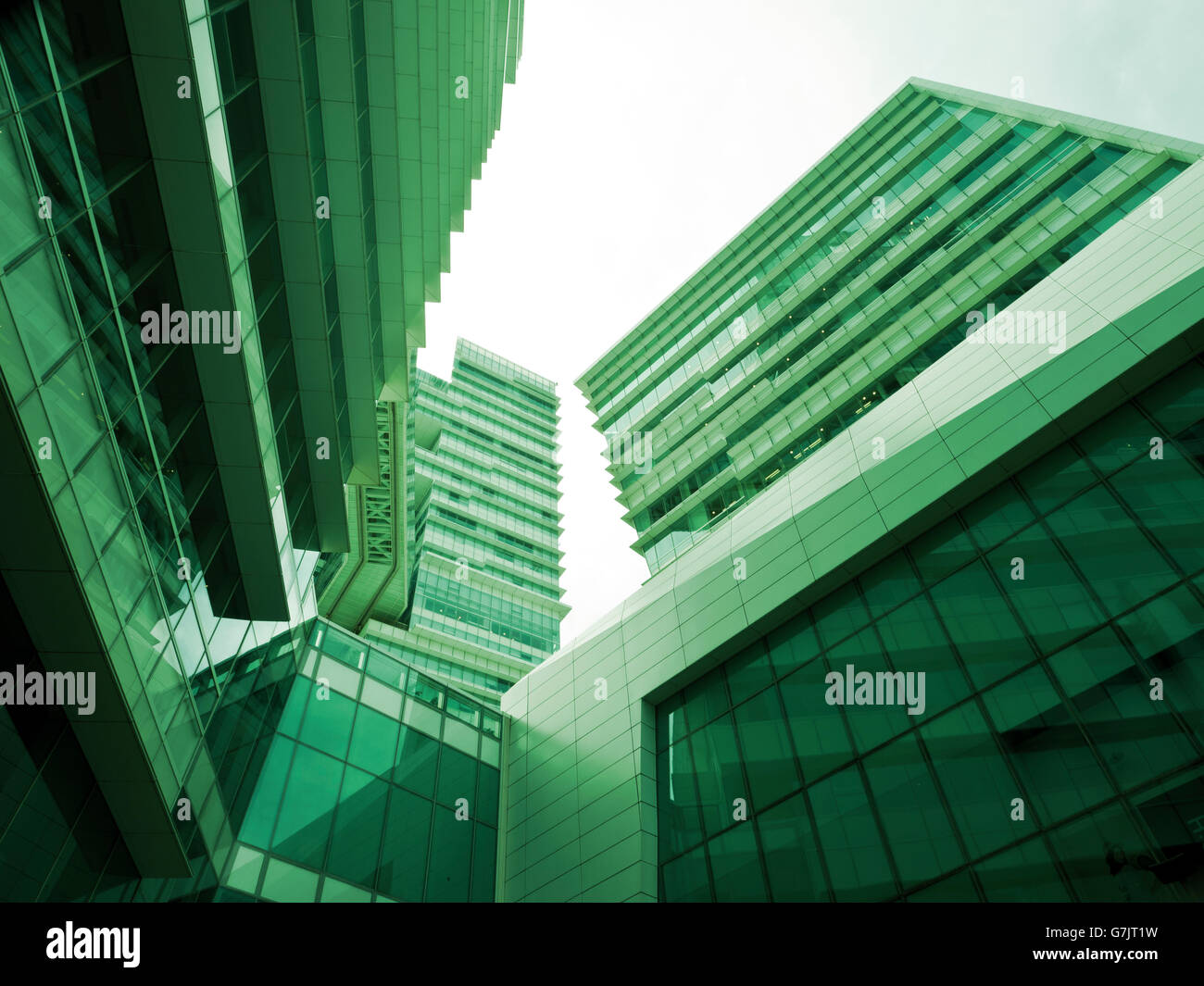 La parte inferiore e panoramica vista prospettica di acciaio vetro verde alto edificio grattacieli, concetto aziendale di successo ind Foto Stock