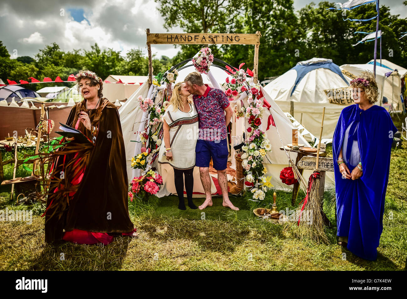 Fiona Wilkins, 33 da Hartepool e Craig Robson, 41 da Hartlepool partecipare ad una tradizionale cerimonia handfasting detenute da cerimonia celebranti Jayne Tobey (destra) e Glenda Procter (sinistra) presso il festival di Glastonbury, presso l'azienda agricola degna in Somerset. Stampa foto di associazione. Vedere PA storia SHOWBIZ Glastonbury matrimonio. Picture Data: Sabato 25 Giugno, 2016. Foto di credito dovrebbe leggere: Ben Birchall/PA FILO Foto Stock