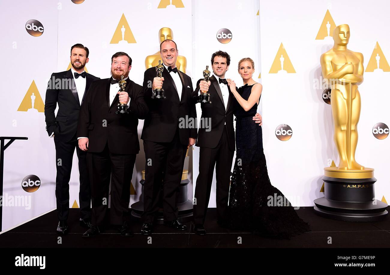 Sienna Miller e Chris Evans (all'estrema sinistra) presentano Thomas Curley (seconda a sinistra), Craig Mann (seconda a destra) e ben Wilkins con il premio per il miglior mixaggio sonoro per 'Whiplash', nella sala stampa dell'87esimo Academy Awards tenutosi al Dolby Theatre di Hollywood, Los Angeles, CA, USA, febbraio 22, 2015. Foto Stock