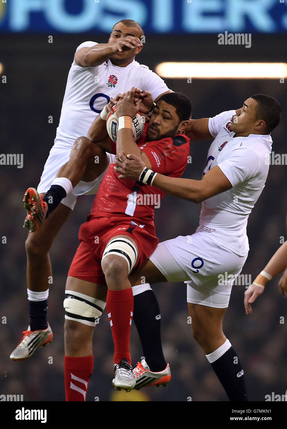 Taulupe Faletau (centro) del Galles rivendica la palla sotto pressione di Jonathan Joseph (a sinistra) e Luther Burrell (a destra) in Inghilterra durante la partita RBS 6 Nations al Millennium Stadium di Cardiff. Foto Stock