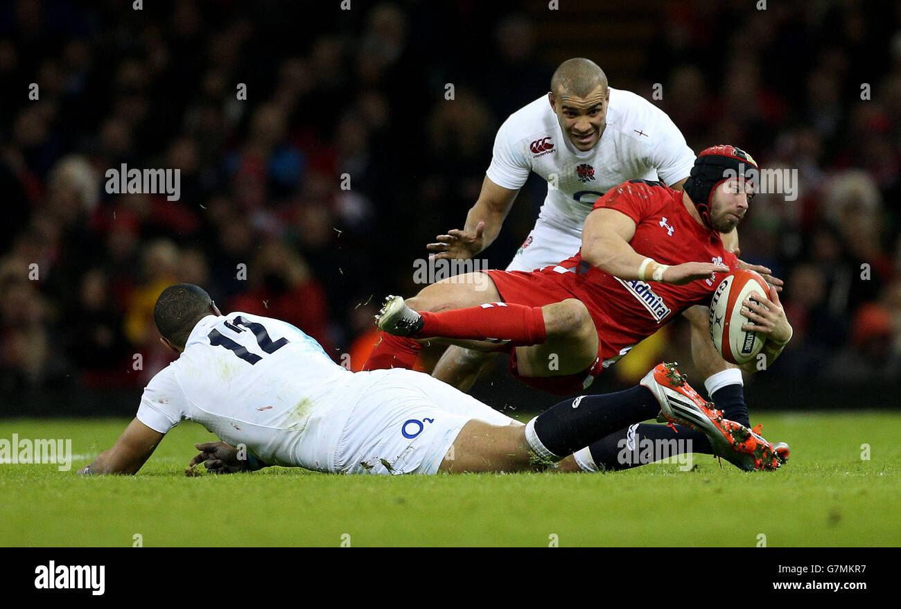 Wales Leigh Halfpenny è combattuto da Luther Burrell e Jonathan Joseph in Inghilterra durante la partita RBS 6 Nations al Millennium Stadium di Cardiff. Foto Stock