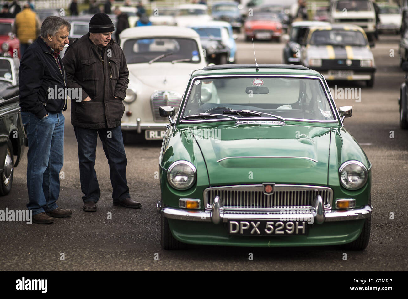 La gente ammira un'auto classica MG MGB Roadster al Great Western Autojumble, Bath & West Showground, Somerset, dove gli appassionati di auto si sono riuniti per festeggiare i veicoli d'epoca. Foto Stock