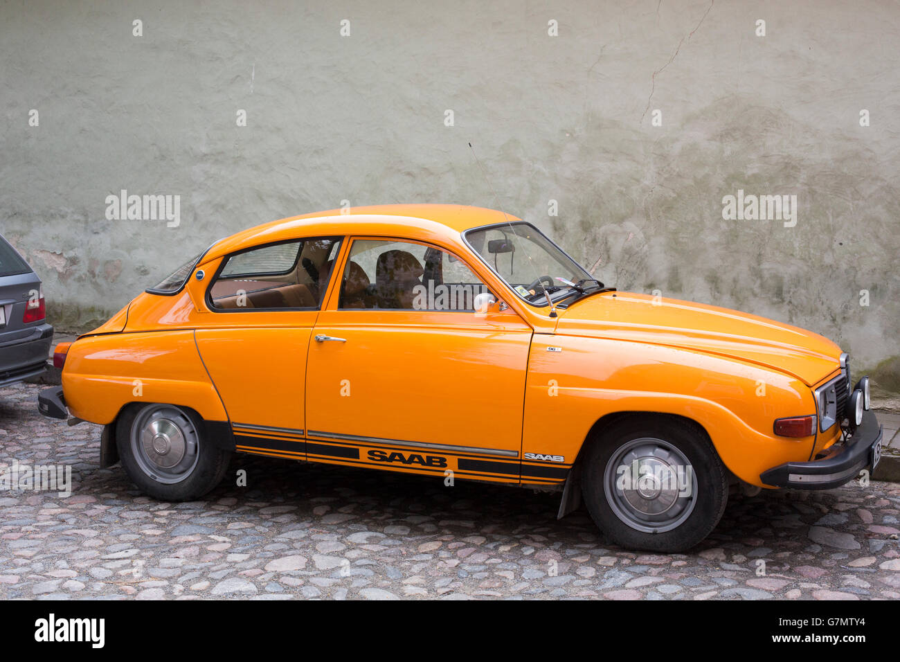 Saab 96 in "70's di colore arancione, parcheggiato in una strada di Tallinn, Estonia, Europa UE Foto Stock