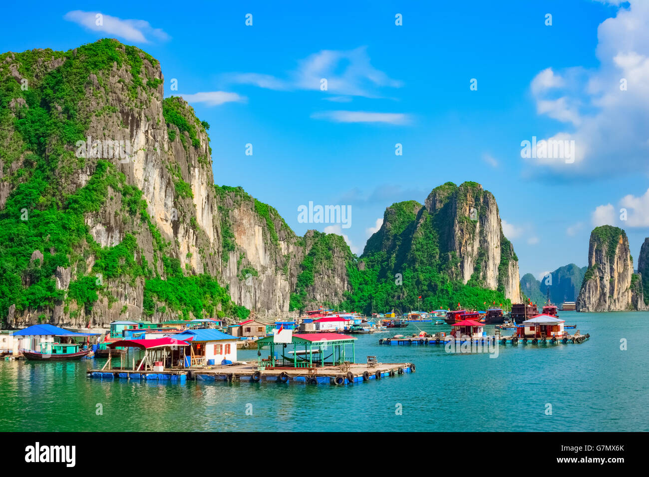 Floating villaggio di pescatori e le isole della roccia nella baia di Halong, Vietnam, sud-est asiatico. UNESCO - Sito Patrimonio dell'umanità. Foto Stock