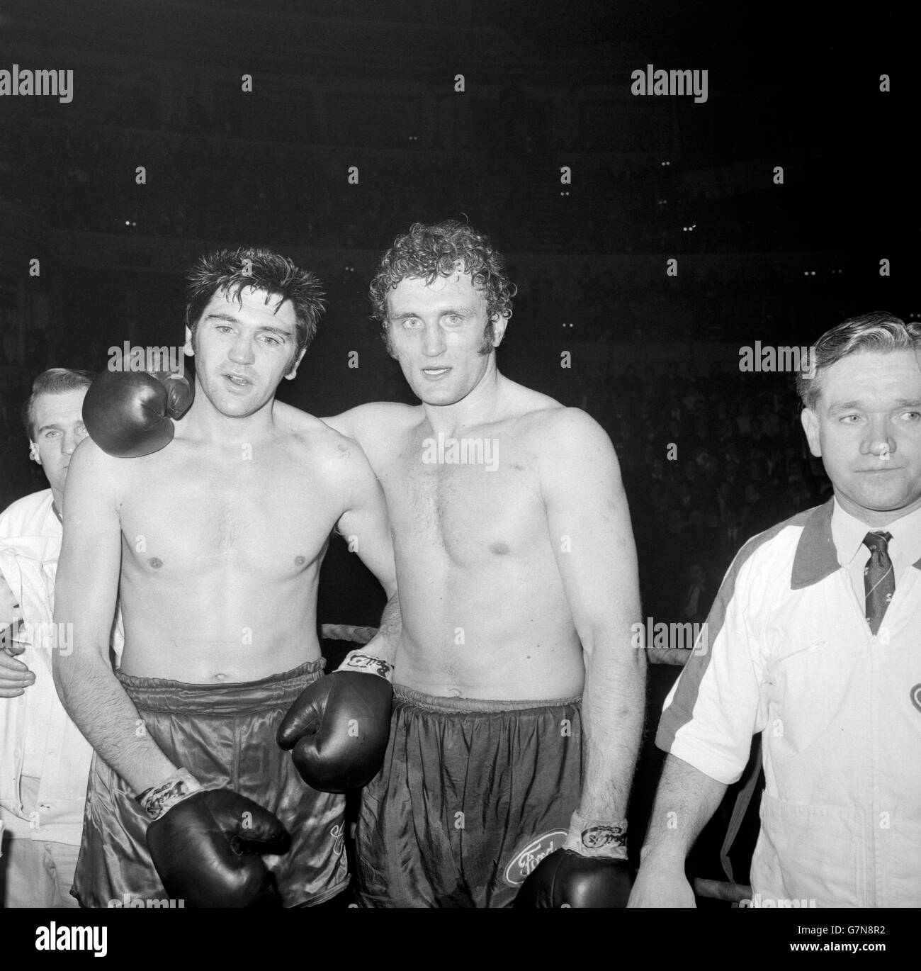 Il vincitore Joe Bugner (r), di St Ives, Huntingdonshire, mette il suo braccio intorno al perdente Carl Gizzi, pesi massimi gallesi di Rhyl, dopo la loro lotta alla Royal Albert Hall. Foto Stock