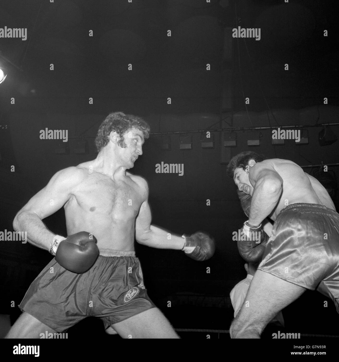 Carl Gizzi, pesi massimi gallesi di Rhyl, cerca di coprire come Joe Bugner (l), di St Ives, si prepara a colpire con un diritto durante la loro lotta alla Royal Albert Hall di Londra. Foto Stock