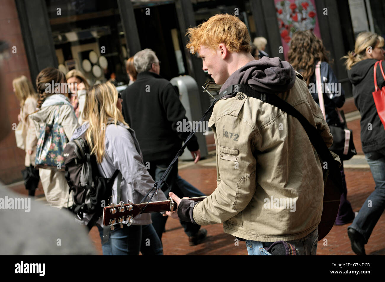 Musicista di strada a suonare la chitarra e armonica in Grafton Street nel centro di Dublino, Irlanda Foto Stock