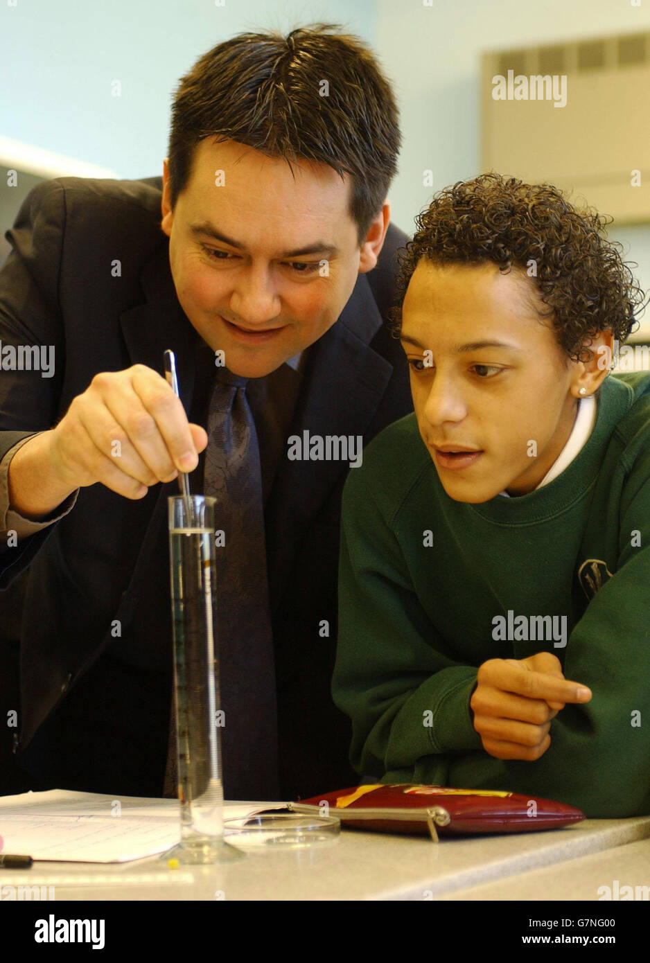 Stephen Twigg, ministro degli standard scolastici, si unisce all'allievo Ashley Regis, 16. In un esperimento per misurare la velocità terminale, utilizzando un cordone di cellule styro in acqua, presso la Oaklands Secondary School. Foto Stock