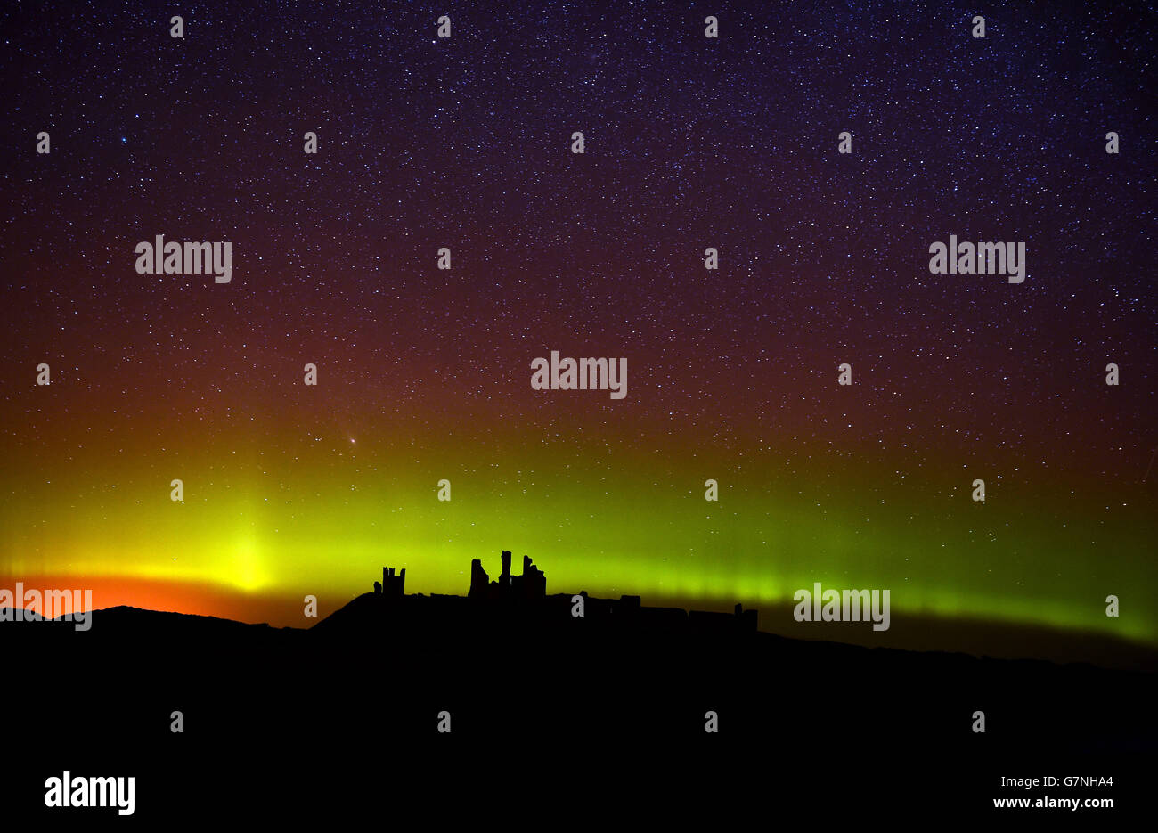 L'aurora boreale, o l'aurora boreale come sono comunemente conosciuti al castello di Dunstanburgh in Northumberland. Foto Stock