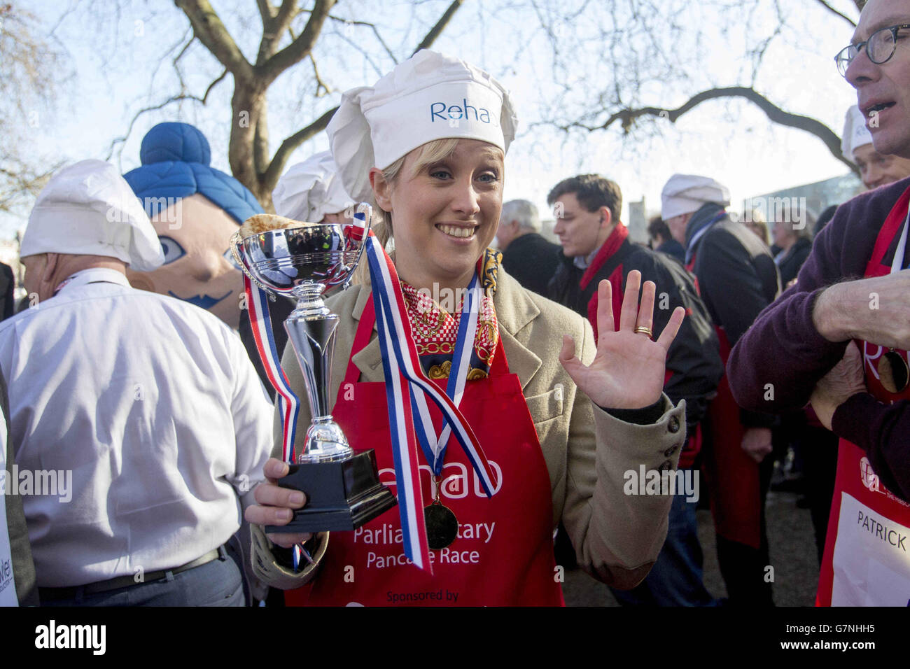 Sophy Ridge of Sky News accetta la gara magnifica Tin Cup con i suoi compagni di team media dopo l'annuale Rehab Parliament Pancake Race in cui MPs, Lord e membri dei media si corrono a vicenda nel giorno pancake per raccogliere denaro per la beneficenza Rehab. Foto Stock