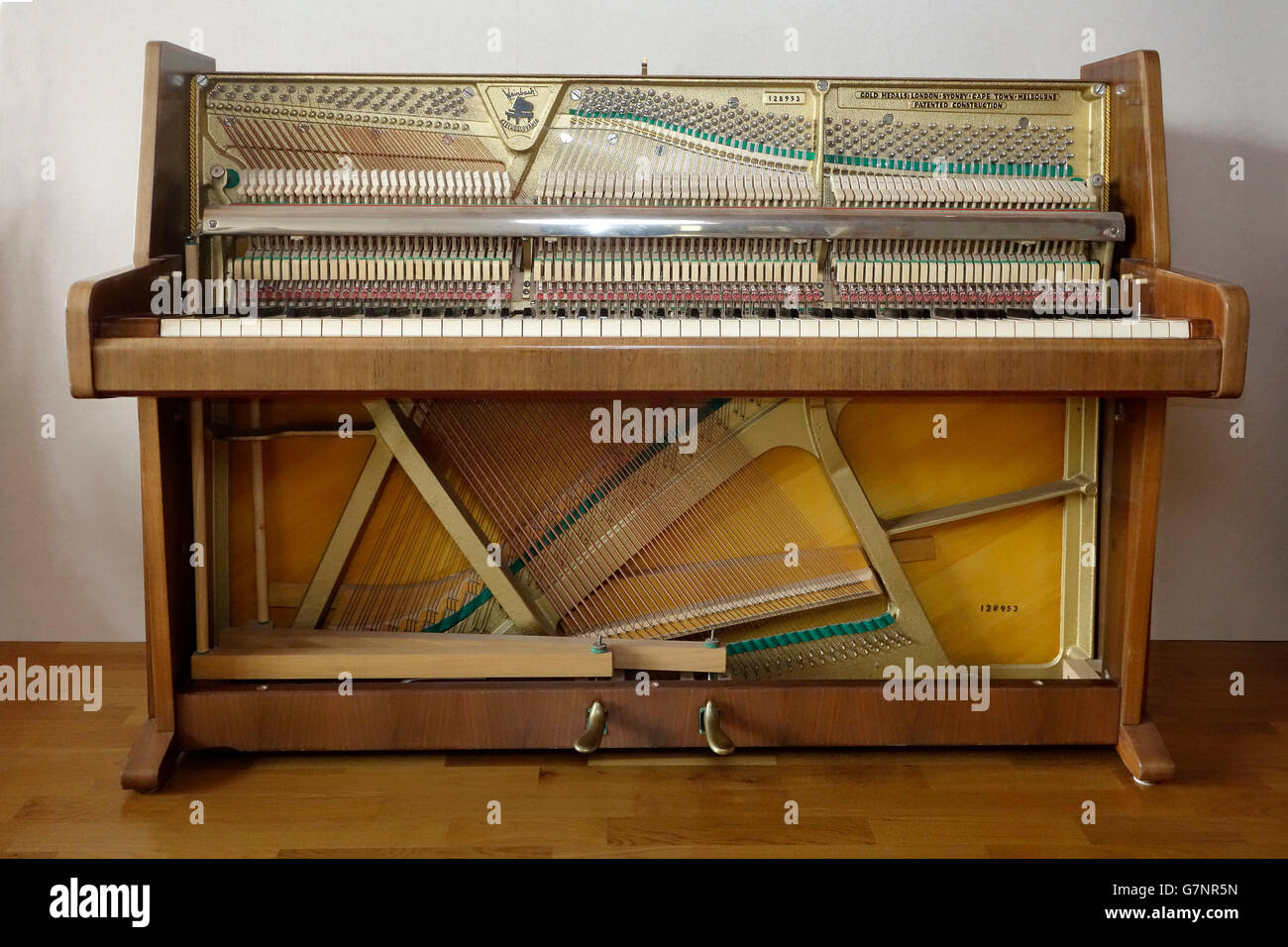 Smontaggio pianoforte verticale spogliato da sportelli anteriori e la caduta che mostra meccanismi interni e stringhe. Foto Stock