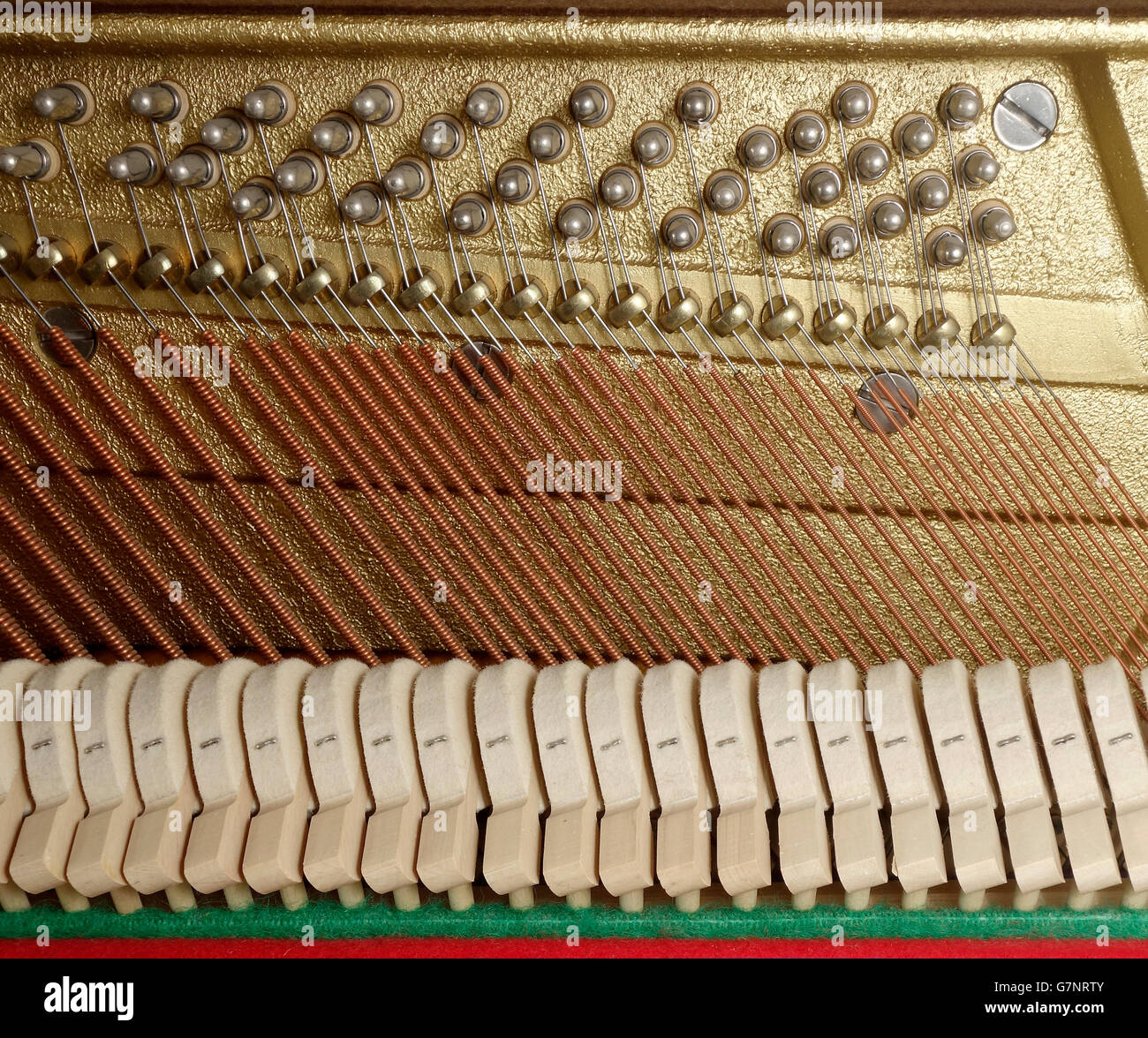 Chiusura del meccanismo di azione su un pianoforte verticale con martelli, bass stringhe, barra a pressione e spine di sintonizzazione Foto Stock