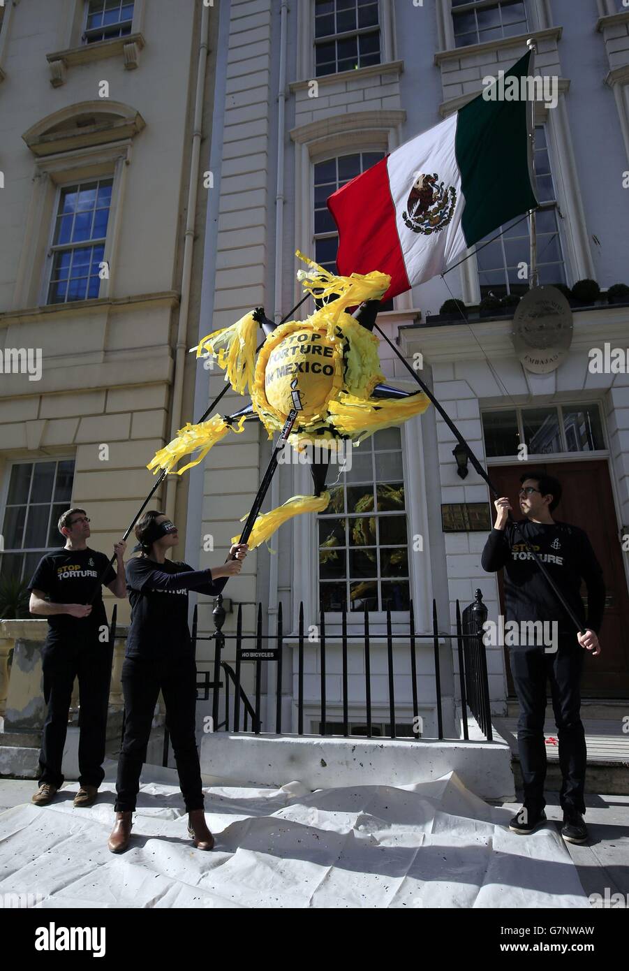 I manifestanti di Amnesty International UK protestano con una pinata fuori dall'ambasciata messicana a St. George's Street, Mayfair, come parte della loro campagna di "TORTURA DI ARRESTO". Foto Stock