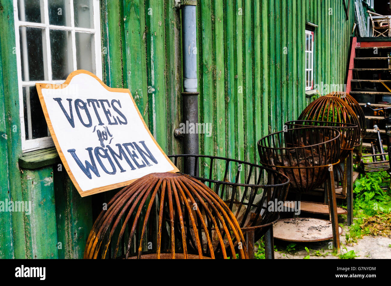 Segno al di fuori di un verde casa in legno dicendo "voti per le donne" Foto Stock