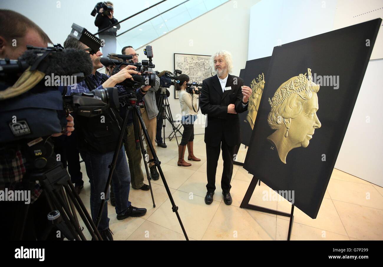 Un assistente di eventi della zecca reale tiene una nuova moneta da due libbre davanti al ritratto di Jody Clark del nuovo inconio della regina Elisabetta II durante una cerimonia di inaugurazione per l'ultimo ritratto di conio della regina Elisabetta II alla National Portrait Gallery di Londra. Foto Stock