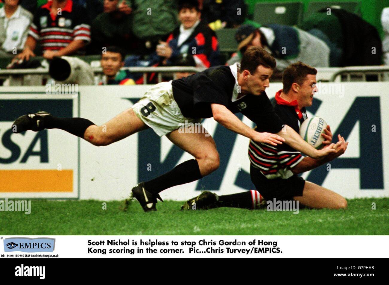 Rugby World Cup 7 's-Hong Kong Scozia / Hong Kong. Scott Nichol è impotente per fermare Chris Gordon di Hong Kong segnando in curva. Foto Stock