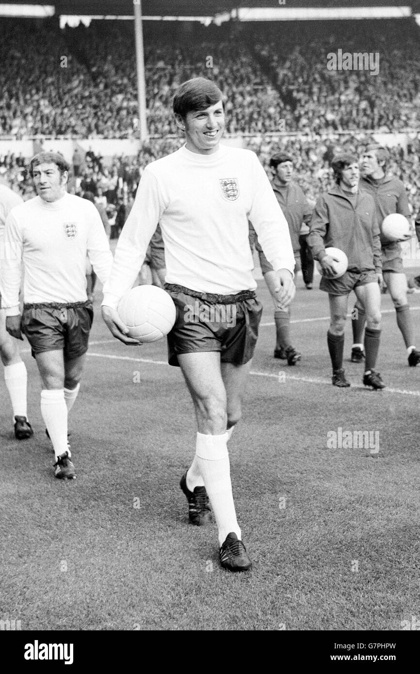 Martin Peters, in Inghilterra, si accanisce mentre guida la sua squadra alla sua prima apparizione come capitano, seguita dal compagno di squadra Ralph Coates (l) Foto Stock