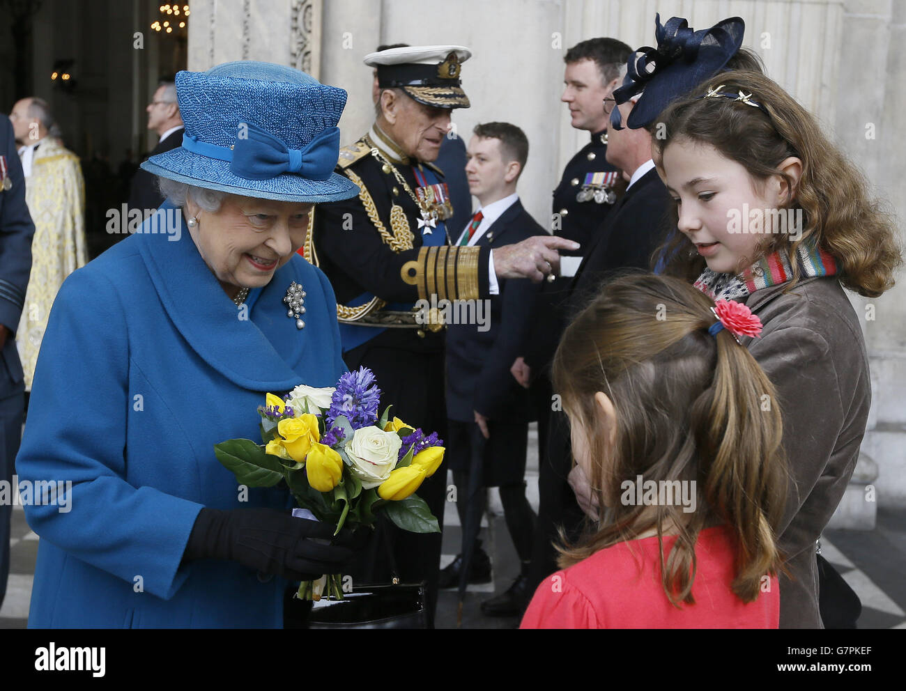 La regina Elisabetta II riceve i fiori dalle suore Sophie e Hannah Thorneloe, il cui padre il tenente colonnello Rupert Thoneloe è stato ucciso in Afghanistan, in quanto hanno partecipato a un servizio di commemorazione per celebrare la fine delle operazioni di combattimento in Afghanistan presso la cattedrale di St Pau, Londra. Foto Stock