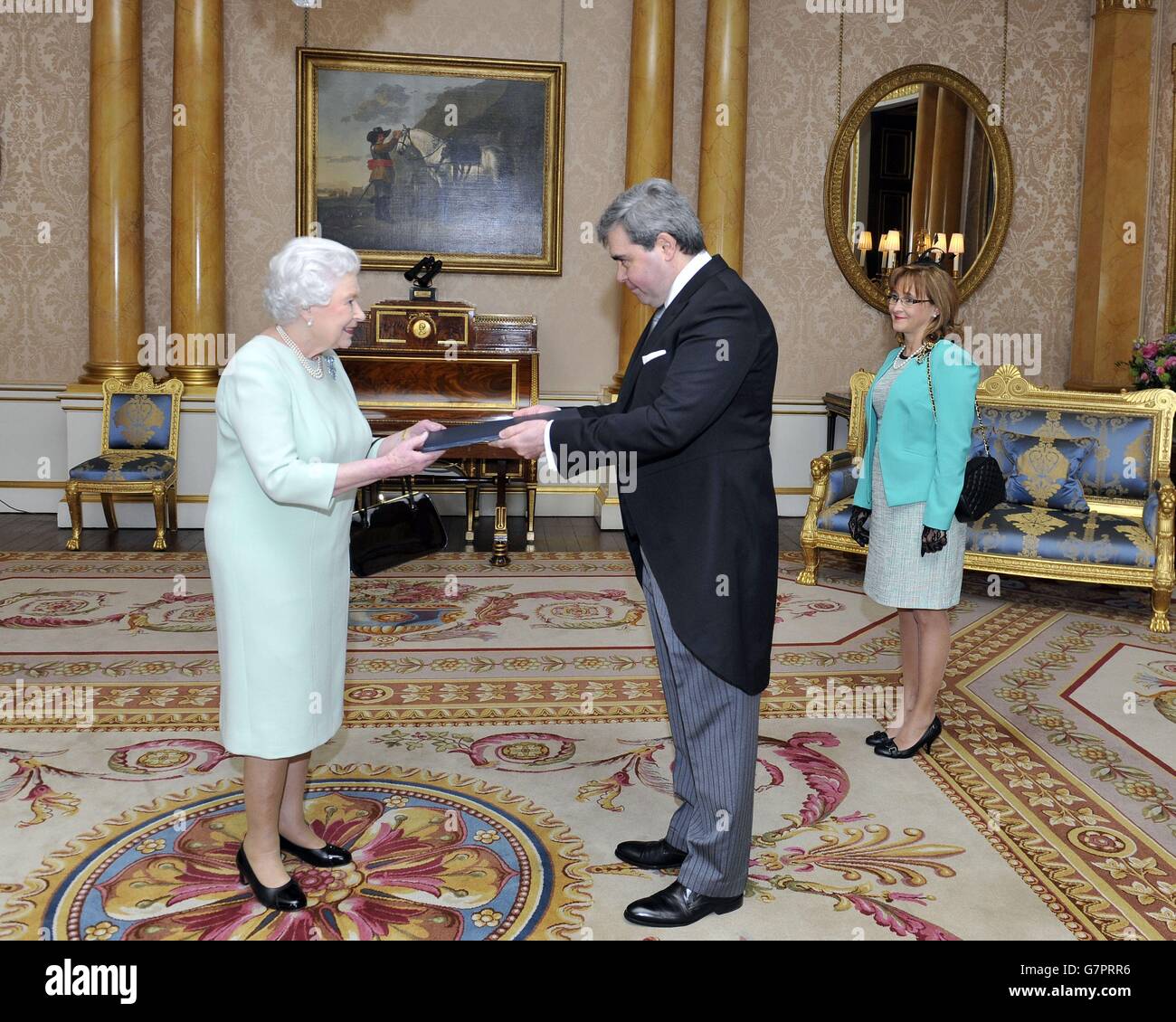 La sig.ra Maria Carolina Silveira (destra) guarda come sua Eccellenza Fernando Lopez-Fabregat, presenta le lettere di richiamo del suo predecessore e le sue lettere di credito come Ambasciatore dell'Uruguay presso la Corte di San Giacomo, durante un'udienza con la regina Elisabetta II a Buckingham Palace, Londra. Foto Stock