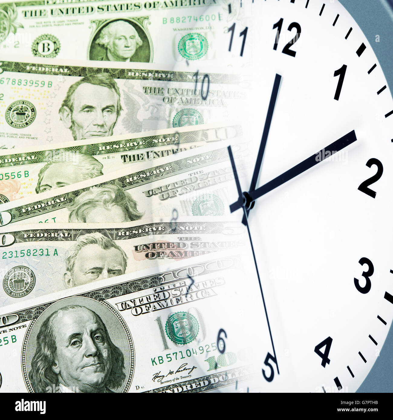 Orologio su un assortimento di banconote americane. Il tempo è denaro idea Foto Stock