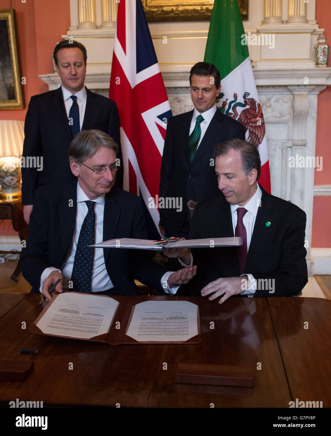 Il Segretario degli Esteri Philip Hammond (a sinistra) e il suo omologo messicano Jose Antonio Meade Kuribrena firmano una dichiarazione di cooperazione tra i due Paesi, cui hanno assistito il primo Ministro David Cameron e il Presidente messicano Enrique pena Nieto all'interno del 10 Downing Street, Londra, il secondo giorno della sua visita di stato. Foto Stock