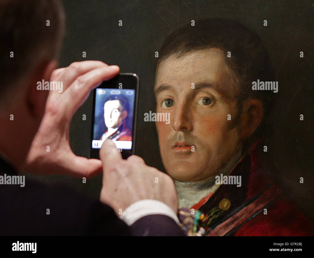 Un visitatore che prende un telefono cellulare immagine di un ritratto di Arthur Wellesley, i duca di Wellington, di Francisco de Goya, 1812-14, durante una rassegna stampa di Wellington: Triumphs, Politics and Passions alla National Portrait Gallery di Londra. Foto Stock