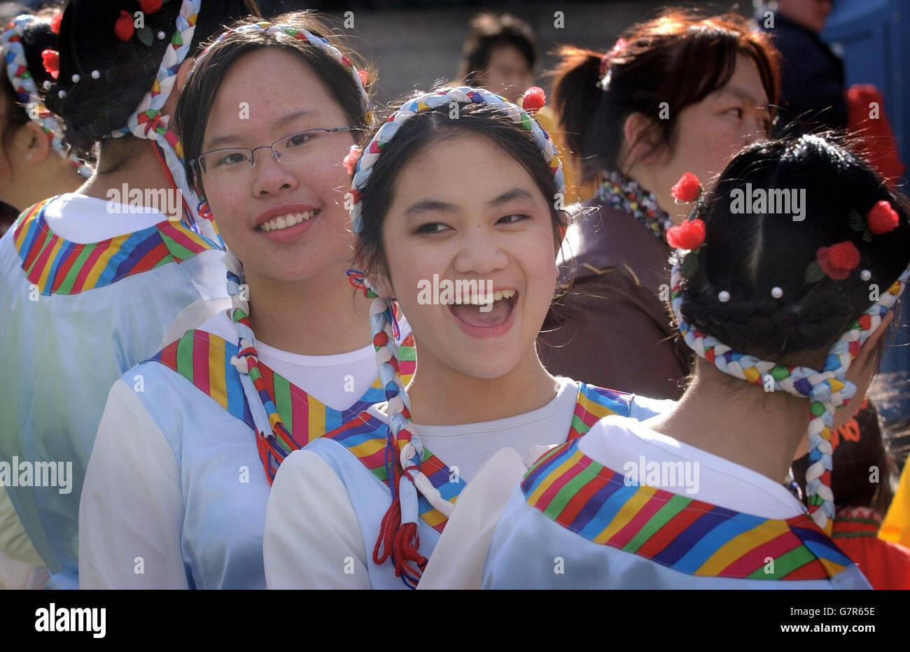 Le ragazze cinesi prendono parte ad una sfilata del costume per celebrare l'anno del roster. Foto Stock