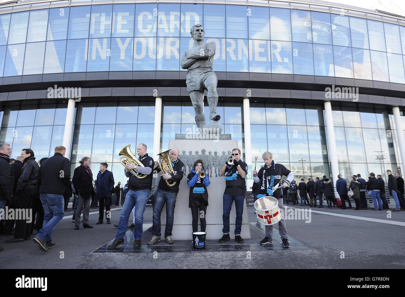 La band dei sostenitori dell'Inghilterra suona come la band Men United Esibiti accanto alla statua di Bobby Moore a Wembley in Aiuto del cancro della prostata UK Foto Stock