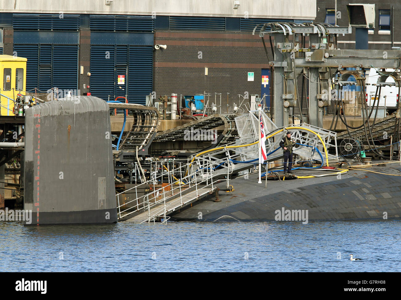 Un soldato sul retro di HMS vittorioso un sottomarino di classe Vanguard alla sua base presso la base navale di HM Clyde. Foto Stock