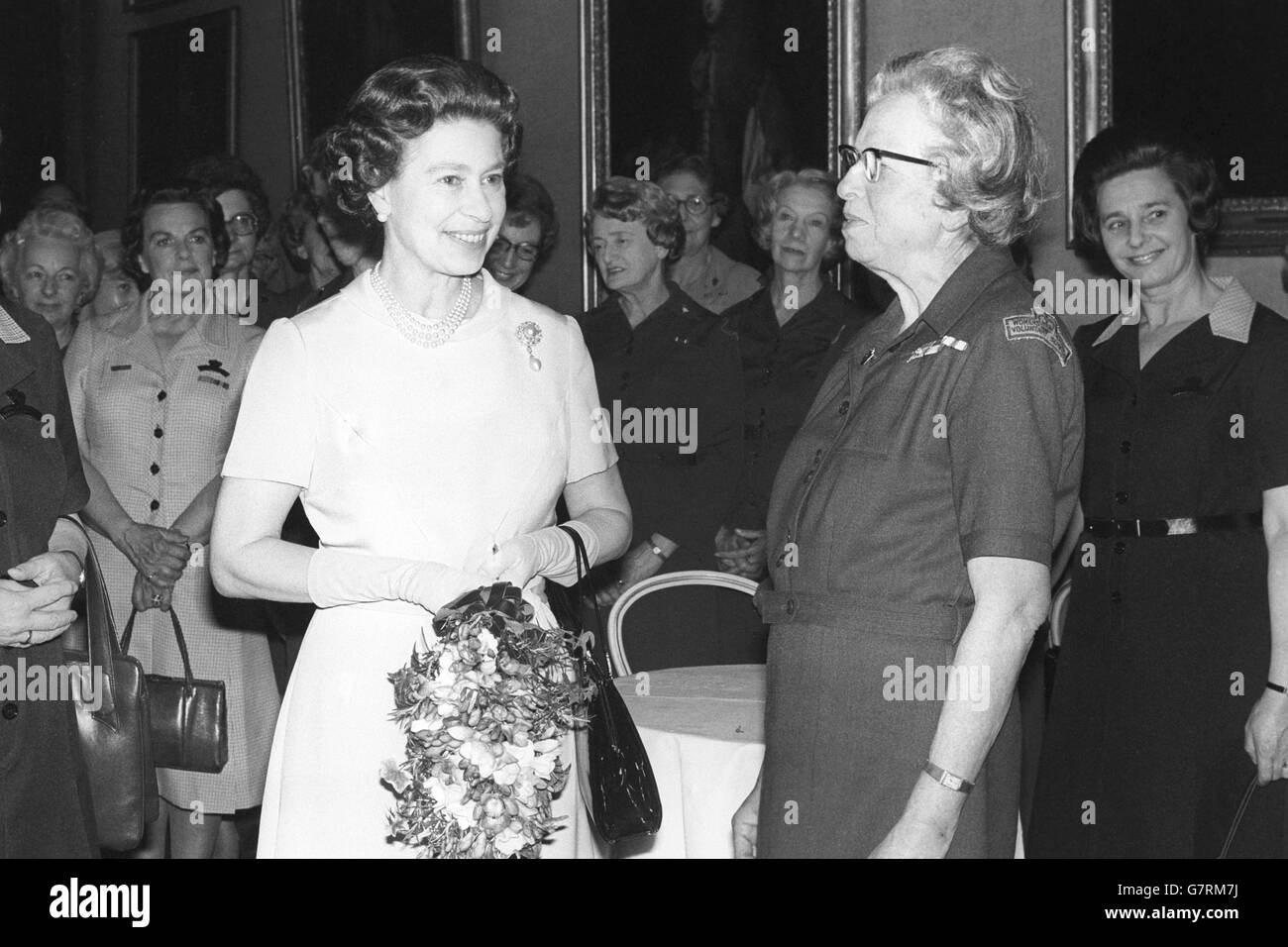 La Regina parla con Doreen Harris, 75 anni, di Sloane Square, Londra, che le ha presentato un bouquet quando ha partecipato ad un ricevimento dato dal Servizio volontario reale delle Donne a St James's Palace, Londra. La sig.ra Harris è entrata a far parte dell'organizzazione nel 1938, anno in cui è stata fondata come WVS. Foto Stock