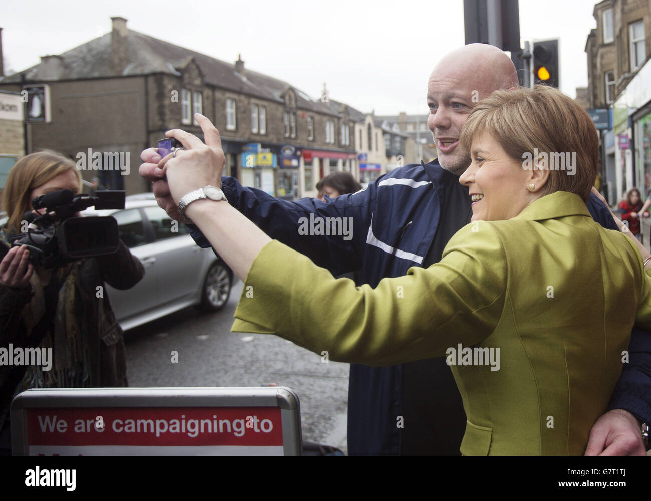 Il primo ministro Nicola Sturgeon prende un selfie con un sostenitore sulla pista di campagna a Edimburgo come illustra come il piano anti-austerità della SNP stimolerà il NHS della Scozia mentre. Foto Stock