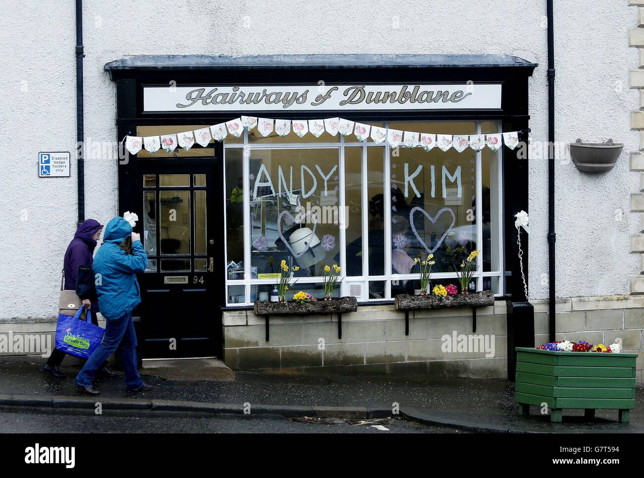 La gente passa davanti alla finestra di un parrucchiere a Dunblane, con i nomi del tennis britannico numero uno Andy Murray e la sua fidanzata di lunga data Kim Sears, che si sposerà alla cattedrale di Dunblane nella sua città natale più tardi oggi. Foto Stock La gente passa davanti alla finestra di un parrucchiere a Dunblane, con i nomi del tennis britannico numero uno Andy Murray e la sua fidanzata di lunga data Kim Sears, che si sposerà alla cattedrale di Dunblane nella sua città natale più tardi oggi. Foto Stock