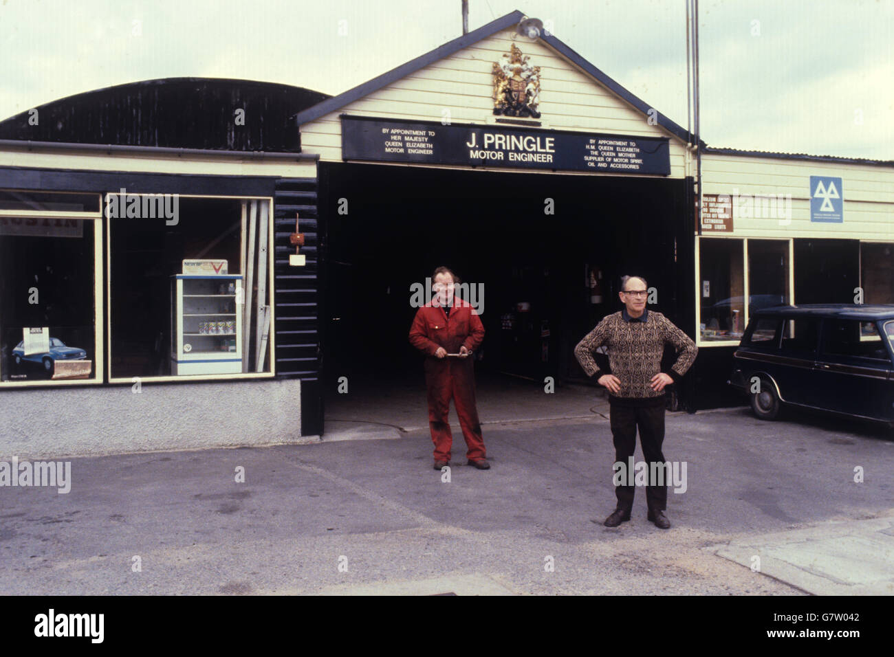 Il proprietario del garage John Pringle si trova fuori dal suo garage a Ballater, Aberdeenshire, vicino alla casa vacanze della famiglia reale al Castello Balmoral. Ripara le auto reali, e ha un reale mandato sul suo edificio. Foto Stock